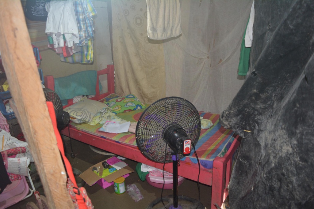 Beneficiaria del programa de mejoramiento de vivienda de Banasan mostrando su hogar renovado.